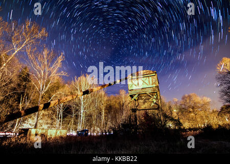 Diese lange Exposition Bild zeigt Star Trails in der Nacht Himmel über eine Industrial Szene. Stockfoto