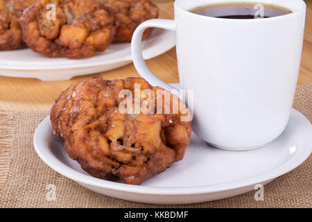 Glasierte Apfel Krapfen und Kaffee auf einer weißen Platte Stockfoto