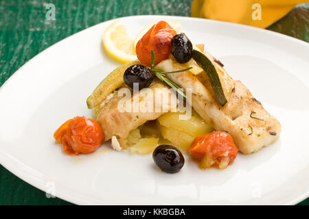 Foto von leckeren gebackenen Kabeljau mit Oliven und Tomaten Stockfoto