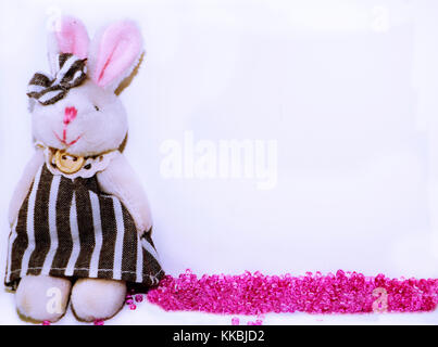 Cute Baby frame oder Vorlage mit Plüsch bunny und verschüttete rose Perlen und Platz für Text auf weißem Hintergrund. Stockfoto