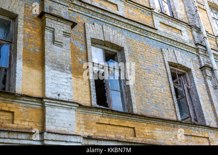 Zerbrochene Fenster in einem alten, verlassenen Ziegelgebäude Stockfoto