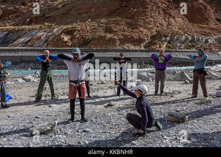 Sie strecken sich, bevor Sie auf die Flöße steigen, um die SCHLUCHT DES ZANSKAR RIVER hinunter zu fahren - ZANSKAR, LADAKH, INDIEN Stockfoto