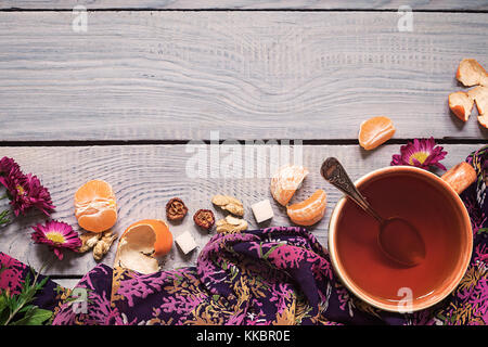Tasse Kaffee, Blumen und Tangerine auf weissem Holztisch Stockfoto