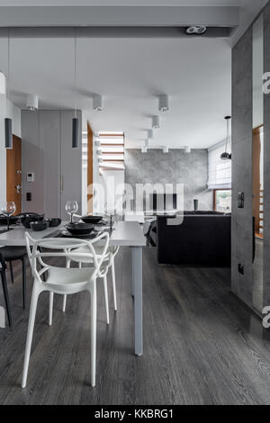 Moderne Inneneinrichtung mit weißem Esstisch und Stühlen Stockfoto