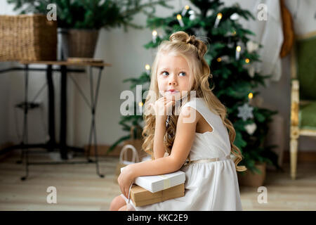 Eine kleine süße Mädchen Träume von Geschenken. Ein nettes Mädchen machen möchten. frohe Weihnachten und schöne Feiertage Stockfoto