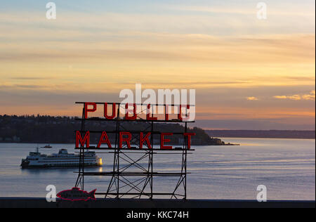 SEATTLE, USA - 25. MÄRZ 2016: Ruhige Sonnenuntergang über dem Puget Sound am 25. März, in Seattle, USA 2016. Rot fluoreszierende Zeichen von Seattle berühmten öffentlichen Markt ein Stockfoto