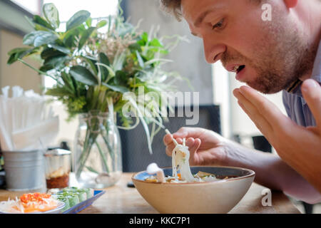 Kaukasische Mann fühlen, lassen Sie sich überraschen mit wie würzige Nudeln in der Suppe ist. Stockfoto