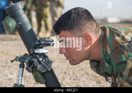 Eine irakische Sicherheitskräfte Mitglied schaut durch den Sucher zu einem simulierten Ziel während der Mörtel Training im Camp Taji, Irak, Okt. 22, 2017. Camp Taji ist einer von vier CJTF-OIR Aufbau der Kapazitäten Standorte Ausbildung Partner Kräfte und Verstärkung ihrer Wirksamkeit auf dem Schlachtfeld gewidmet. CJTF-OIR ist die globale Koalition zu besiegen ISIS im Irak und in Syrien. (U.S. Armee Foto von SPC. Alexander Holmes) Stockfoto