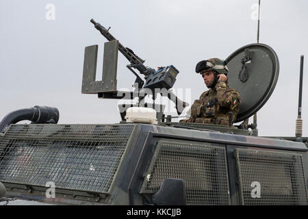 Eine italienische Armee Soldat zieht sich seine persönliche Schutzausrüstungen für einen Konvoi Unterstützung von Zug, unterstützen, beraten Command-West auf Unterstützung Base Camp Arena, Afghanistan, Nov. 13, 2017. TAAC - West führt funktionell Sicherheit Kraft Hilfe, um der Afghanischen Nationalen Verteidigungs- und Sicherheitskräfte selbst zu maximieren - Erhalt der Fähigkeit der Afghanischen Bevölkerung in strategischen Bereichen zusammengeschlossen, um Regionen zu sichern und die afghanische Regierung fördern. (U.S. Air Force Foto: Staff Sgt. Sean Martin) Stockfoto