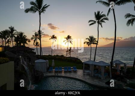 Sonnenuntergang am Wailea Beach, vom Four Seasons Resort Maui at Wailea aus gesehen, Palmen und Pool sichtbar, Wailea, Maui, Hawaii, 2016. Stockfoto