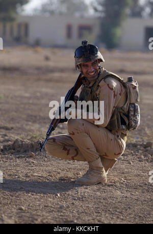 Ein Mitglied der irakischen Sicherheitskräfte betrachtet ein mannschaftskamerad Während ländliche Combat Training im Camp Taji, Irak, Nov. 18, 2017. Camp Taji ist einer von vier Combined Joint Task Force - inhärenten Building Partner Kapazität beheben Standorte Ausbildung Partner Kräfte und Verstärkung ihrer Wirksamkeit auf dem Schlachtfeld gewidmet. CJTF-OIR ist die globale Koalition zu besiegen ISIS im Irak und in Syrien. (U.S. Armee Foto von Cpl. Rachel Diehm) Stockfoto