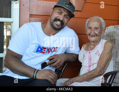 Hector Martinez, Waterford Regional Feuerwehrmann in Michigan und 109-jährige Elsa Maldonado aus Salinas, Puerto Rico, verbringen einen Moment zusammen während einer Haus-zu-Haus-Zustellung Aufwand liefern muss mit Hilfe der Freunde, der Familie und der Feuerwehrmänner aus dem Raum Metro-Detroit, Mich., Nov. 22, 2017. Von der Muniz Air National Guard Station, San Juan, Puerto Rico unterstützt mit der endgültigen könnte und Arbeitskräfte, die dringend benötigte Versorgung der Sturm tobte zu bringen Flieger - Bewohner der Insel nach dem Hurrikan Maria. (U.S. Air National Guard Foto von Master Sgt. Chris Botzum) Stockfoto