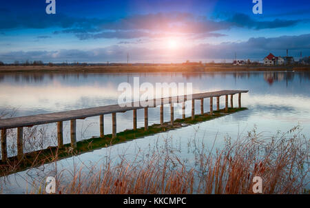 Sonnenuntergang auf alten hölzernen Steg am See Stockfoto