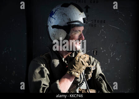 OCALA, Florida (Nov 28, 2017) Naval Air Crewman (Hubschrauber) 2nd Class Connor Murray aus Rhinebeck, New York, beobachtet, wie ein MH-60S Sea Hawk an Hubschrauber Sea Combat Squadron 28 fliegt Pinecastle Range in Ocala, Florida, für eine Live-Feuer-Übung. Das amphibische Angriffsschiff Iwo Jima, Komponenten der Iwo Jima Amphibious Ready Group und der 26. Marine Expeditionary Unit, führen eine kombinierte Composite Training Unit Übung durch, die den Höhepunkt der Ausbildung für das Navy-Marine Corps Team darstellt und sie für den Einsatz zertifizieren wird. (USA Navy Foto von Mass Commun Stockfoto