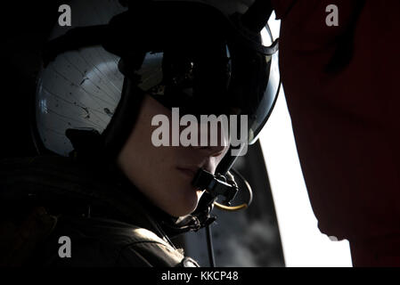 OCALA, Florida (Nov 28, 2017) Naval Air Crewman (Hubschrauber) 3rd Class Jonathan Sponsler vom State College, Pennsylvania, beobachtet, wie ein MH-60S Sea Hawk an Hubschrauber Sea Combat Squadron 28 fliegt Pinecastle Range in Ocala, Florida, für eine Live-Feuer-Übung. Das amphibische Angriffsschiff Iwo Jima, Komponenten der Iwo Jima Amphibious Ready Group und der 26. Marine Expeditionary Unit, führen eine kombinierte Composite Training Unit Übung durch, die den Höhepunkt der Ausbildung für das Navy-Marine Corps Team darstellt und sie für den Einsatz zertifizieren wird. (USA Navy Foto von Stockfoto