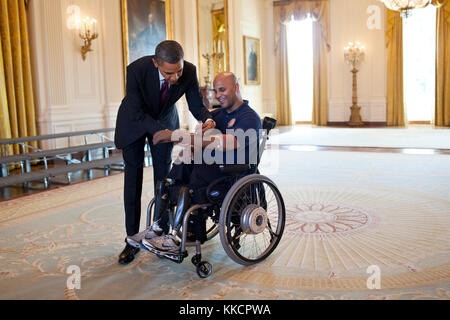 Präsident Barack Obama unterzeichnet die prothetische Arm der Sgt. Carlos Evans, usmc, nach Begrüßung verletzte Krieger im Osten Zimmer während ihrer Tour durch das Weiße Haus, 6. März 2012. der First Lady Michelle Obama traf zuerst Evans, der in Afghanistan verletzt wurde, während auf seiner vierten Bekämpfung Bereitstellung, bei einem Besuch an Walter Reed Army Medical Center im Jahr 2010. Stockfoto