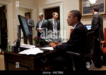 Us-Präsident Barack Obama arbeitet an seine Erklärung zu dem Kompromiss erreicht das Defizit zu verringern und einen Default abzuwenden, in der äußeren Oval Office, Aug. 2., 2011., stehen im Hintergrund sind von links: Director of Communications dan Pfeiffer; drücken Sie die Sekretärin, Jay Carney; Jon Lovett, Associate Director von speechwriting; und Senior Advisor David Plouffe. Stockfoto