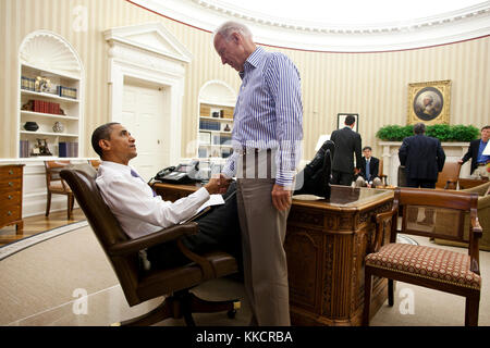 Präsident Barack Obama und Vizepräsident Joe Biden Hände schütteln im Oval Office nach einem Telefonat mit der Sprecherin des Repräsentantenhauses John Boehner sichern ein parteiübergreifendes Angebot Defizit der Nation zu reduzieren und Standard, Sonntag, Juli 31, 2011 zu vermeiden. Stockfoto