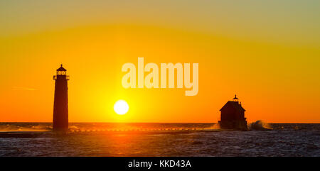 Die Sonne hinter dem Grand Haven, Michigan, Leuchtturm und Mole am Lake Michigan. Stockfoto