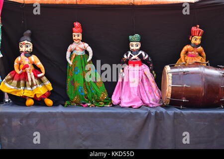 Vier string Puppen zusammen mit einem traditionellen Musikinstrument namens dholki auf Anzeige an der nationalen Handwerk Mela, kalagram, Indien. Stockfoto