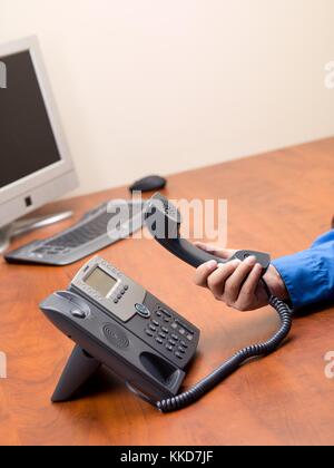 Die menschliche Hand Festnetztelefon an Empfänger in der Hand Stockfoto