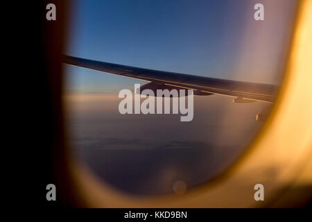 Blick aus dem Flugzeug auf einen Flügel gefärbt mit Sonnenuntergang Licht Stockfoto