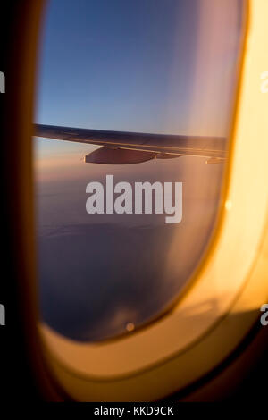 Blick aus dem Flugzeug auf einen Flügel gefärbt mit Sonnenuntergang Licht Stockfoto