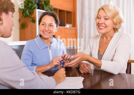 Zwei lächelnde Frau Rentner unter Rechtsauskunft Notar. Fokus auf Brünette Stockfoto