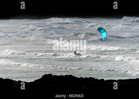 Para-Surfing - ein Kite-Surfer para-Surfer Kitesurfen in rauer See bei Fistral in Newquay Cornwall UK. Stockfoto