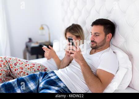 Bild von gelangweilten jungen Paares im Schlafzimmer Stockfoto