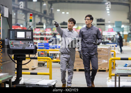 Zuversichtlich chinesische Ingenieure sprechen in der Fabrik Stockfoto