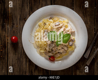 Die Schale von Pilzen und Nudeln mit einem Blatt Salat auf Holz- Hintergrund eingerichtet, Ansicht von oben Stockfoto