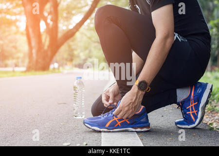 Junge Sportler Schnürsenkel binden auf Sport Schuhe am Anschluss vorbereiten. Training und gesunde Lebensweise. Stockfoto