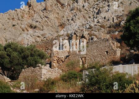 Eine zerstörte alte Gebäude aus Stein, in der vor allem verlassene Dorf chorio auf der griechischen Insel Chalki. Stockfoto