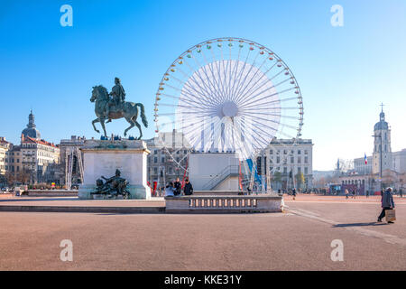 Lyon, Frankreich - 8. Dezember 2016: Bellecour-Platz mit dem Reiterdenkmal von König Ludwig XIV. Und dem großen Riesenrad im Hintergrund Stockfoto