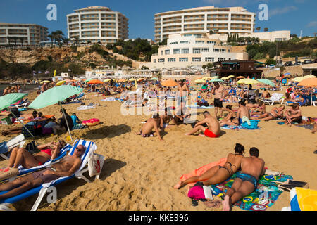 Meer und Sandstrand mit Touristen/Sonnenanbeter Leute genießen, sich Baden Baden von Radisson Blu Resort, Malta Golden Sands übersehen. Stockfoto