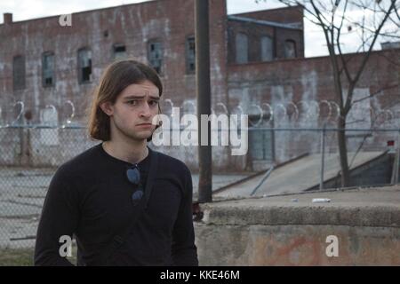 Junger Mann, der vor der abgebrochenen Laderampe Stockfoto