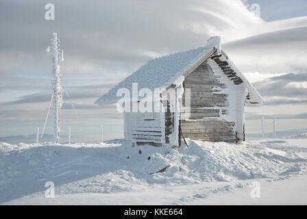 Kleines Haus und gefrorene Antenne auf der Spitze des Berges im Winter mal anmelden Stockfoto