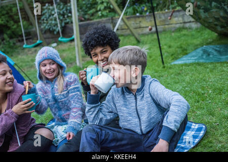 Big wild sleepout Event pix. Bilder der jungen Kinder/Kinder und Eltern, die in Ihrem Garten um von Nachmittag bis in die Nacht - Zeit, genießen Aktivitäten, wie eine Höhle, an Bugs auf der Suche nach Stellen für Hunde Igel, toasten Marshmallows um eine Feuerstelle, die Motten Trapping, auf der Suche nach nachtaktiven Tieren. Stockfoto