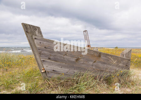 Altes Holzboot mit Schiff Memorial im Hintergrund, Estland Stockfoto