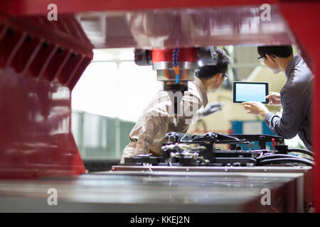 Junge chinesische Ingenieure sprechen in der Fabrik Stockfoto