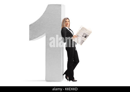 In voller Länge Porträt eine elegante Frau mit einer Zeitung lehnte sich gegen einen Karton Nummer eins auf weißem Hintergrund Stockfoto