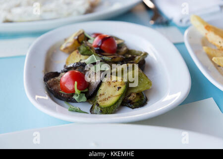 Gebratenes Gemüse auf einem weißen Teller in einem Fine Dining Restaurant. weißen Hintergrund. Stockfoto