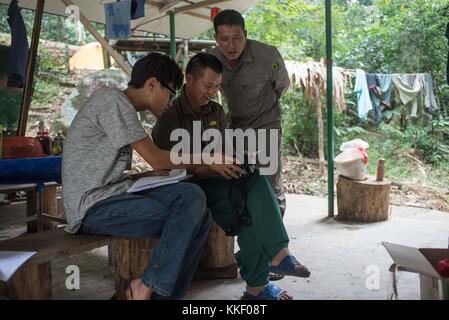 (171202) -- HAIKOU, 2. Dezember 2017 (Xinhua) -- Mitglieder des Hainan Gibbon Monitoring Teams überprüfen Fotos von Hainan Gibbons im Bawangling National Nature Reserve in Changjiang, südchinesische Provinz Hainan, 27. Oktober 2017. Der Hainan Gibbon oder Nomascus Hainanus ist der weltweit seltenste Primaten und wahrscheinlich seltenste Säugetierarten. In den 1950er Jahren zählten sie einst um 2.000, erlebten aber im späten 20. Jahrhundert einen starken Rückgang, der hauptsächlich auf den Verlust von Lebensräumen und die Jagd zurückzuführen war. Typischerweise lebt der Hainan Gibbon mit schwarzem Kamm (Nomascus hainanus) in Regenwaldbäumen über 10 Meter Höhe mit langen Armen und Beinen Stockfoto