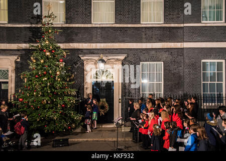 London, Großbritannien. 06 Dez, 2017. Premierminister Theresa May kommt das Licht auf einige Schulkinder - die Downing Street Weihnachtsbaum Leuchten serenaded durch eine traditionelle Kinder Chor singt Weihnachtslieder geschaltet zu wechseln. Credit: Guy Bell/Alamy leben Nachrichten Stockfoto