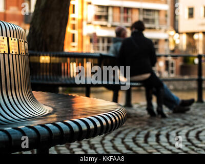 Bristol. Paar auf der Bank sitzen an den Docks in den späten Nachmittag. Stockfoto