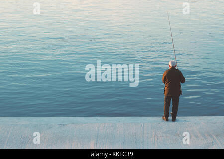 Alte Mann stand am Ufer angeln Stockfoto