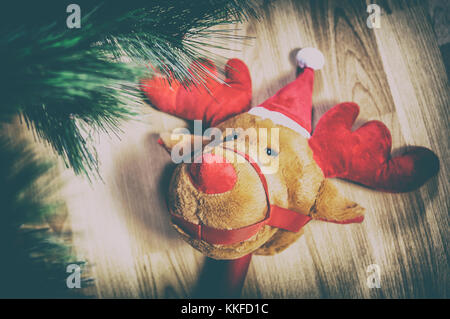 Rentier Plüsch Spielzeug und Holzboden Stick in der Nähe Weihnachtsbaum zu Hause Stockfoto