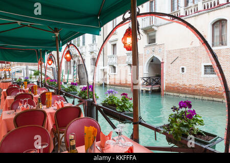 Am Kanal gelegenes Restaurant in Castello, Venice, Italien am Rio del Greci mit Blick auf die leere Menge Tabellen Trattoria Da Giorgio mit Blumenkästen und Laterne Stockfoto