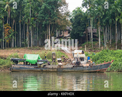 Holz- Frachtschiff entladen Kies und Steine auf einen Lkw durch Pumpen mit Wasser in einem Dorf an der tanintharyi Fluss in der tanintharyi Regi Stockfoto